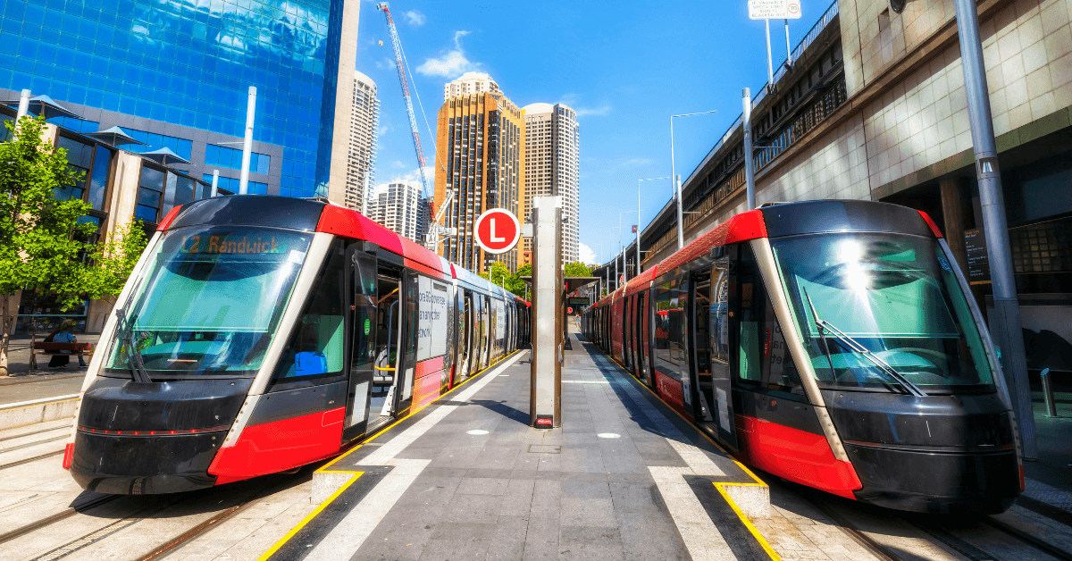 two trams pulling up to a platform