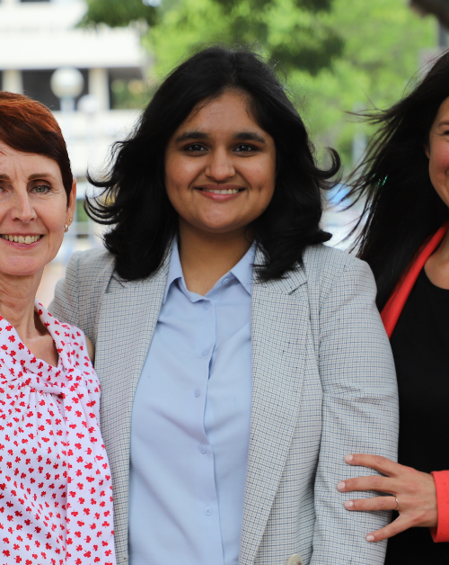 Women at Toustone International Women's Day three female professionals standing together outside building