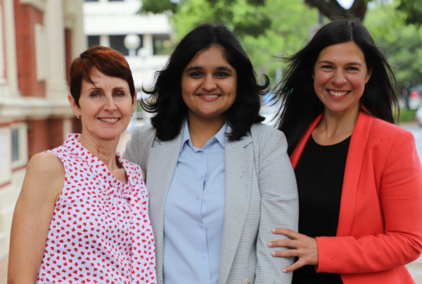 Women at Toustone International Women's Day three female professionals standing together outside building
